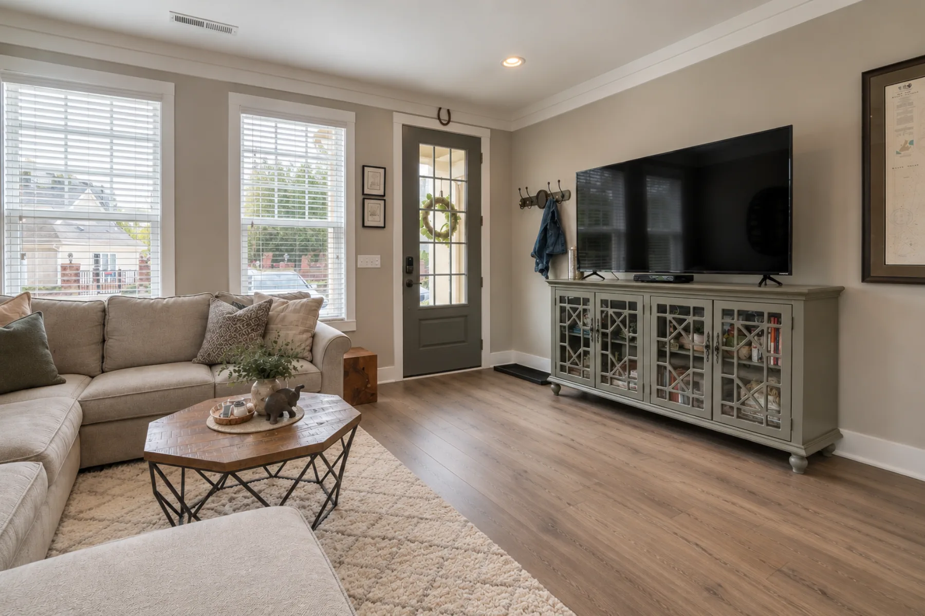 Living room with warm light, neutral furniture and dark wood-look flooring